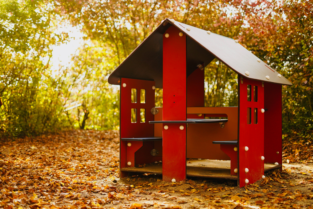 Caseta de juego infantil en un entorno otoñal que ofrece un espacio seguro y divertido para los niños. Perfecta para fomentar el juego al aire libre y dar un toque lúdico y colorido al jardín.